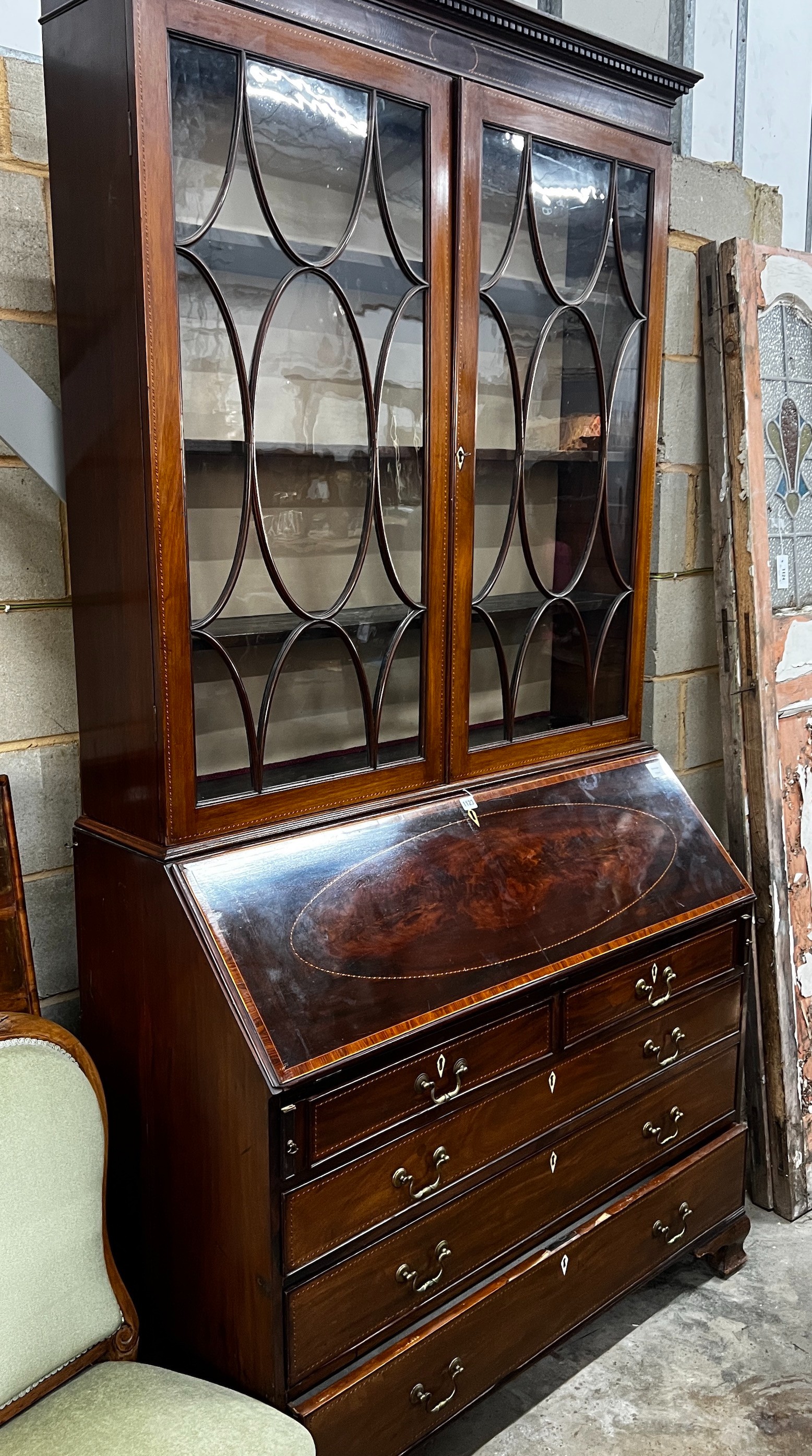 A George III inlaid mahogany bureau, with later top section, width 116cm, depth 51cm, height 232cm